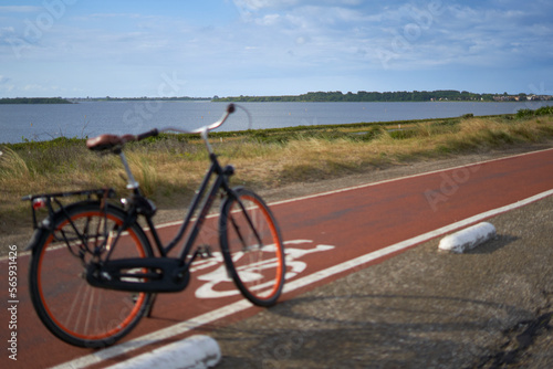 Landscape of Grevelinger sea in Holland. Ladies bike on a bike path in the depth blur. Holland, Zeeland, Brouwersdam.