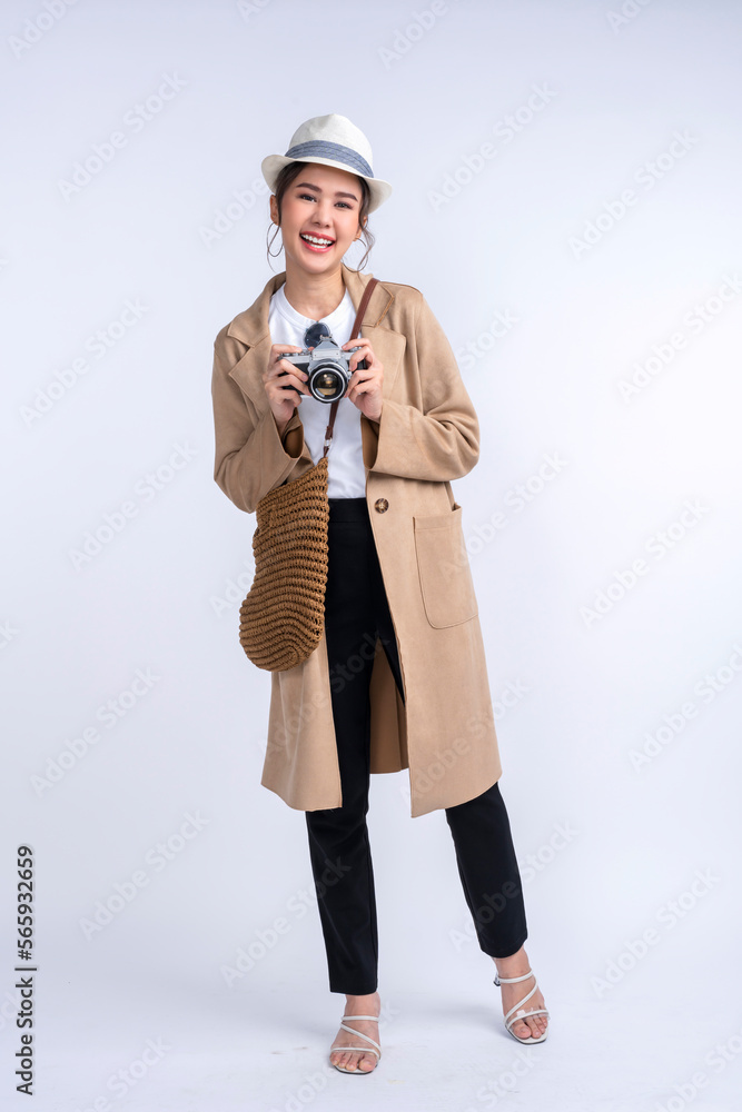 ready to travel ,young teen asian smiling cheerful female woman casual cloth hand hold camera standing with luggage case bag prepare to new abroad journey travel studio shot on white background 