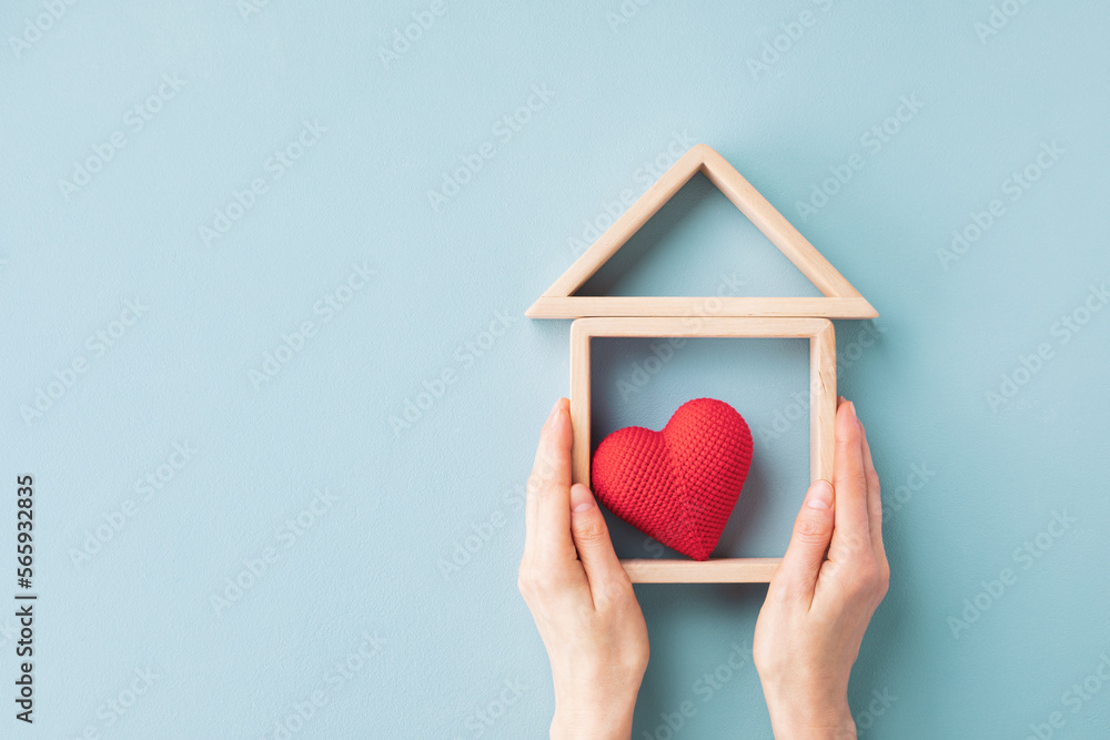 Womans hands holding model of wooden house with red heart for happy family. Real estate, sweet home, housewarming, mortgage and buy new property concept. - obrazy, fototapety, plakaty 