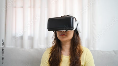 Young Asian woman gamer wearing virtual reality touching air during the VR experience Future home technology player hobby playful enjoyment concept.