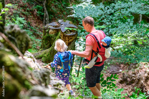 Vater mit Kindern beim Abstieg im unwegsamen Gelände bei einer Bergtour