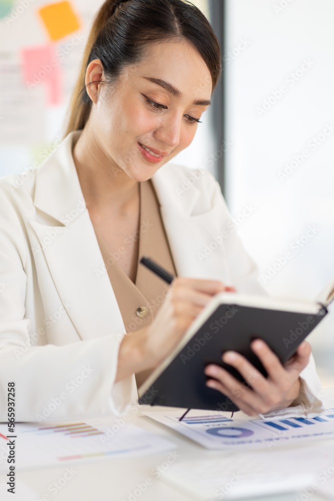Asian Business woman using calculator and laptop for doing math finance on an office desk, tax, report, accounting, statistics, and analytical research concept
