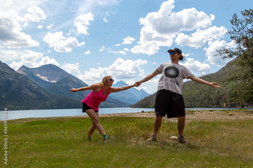 couple being silly in the mountains in front of lake couple being silly in the mountains in front of lake