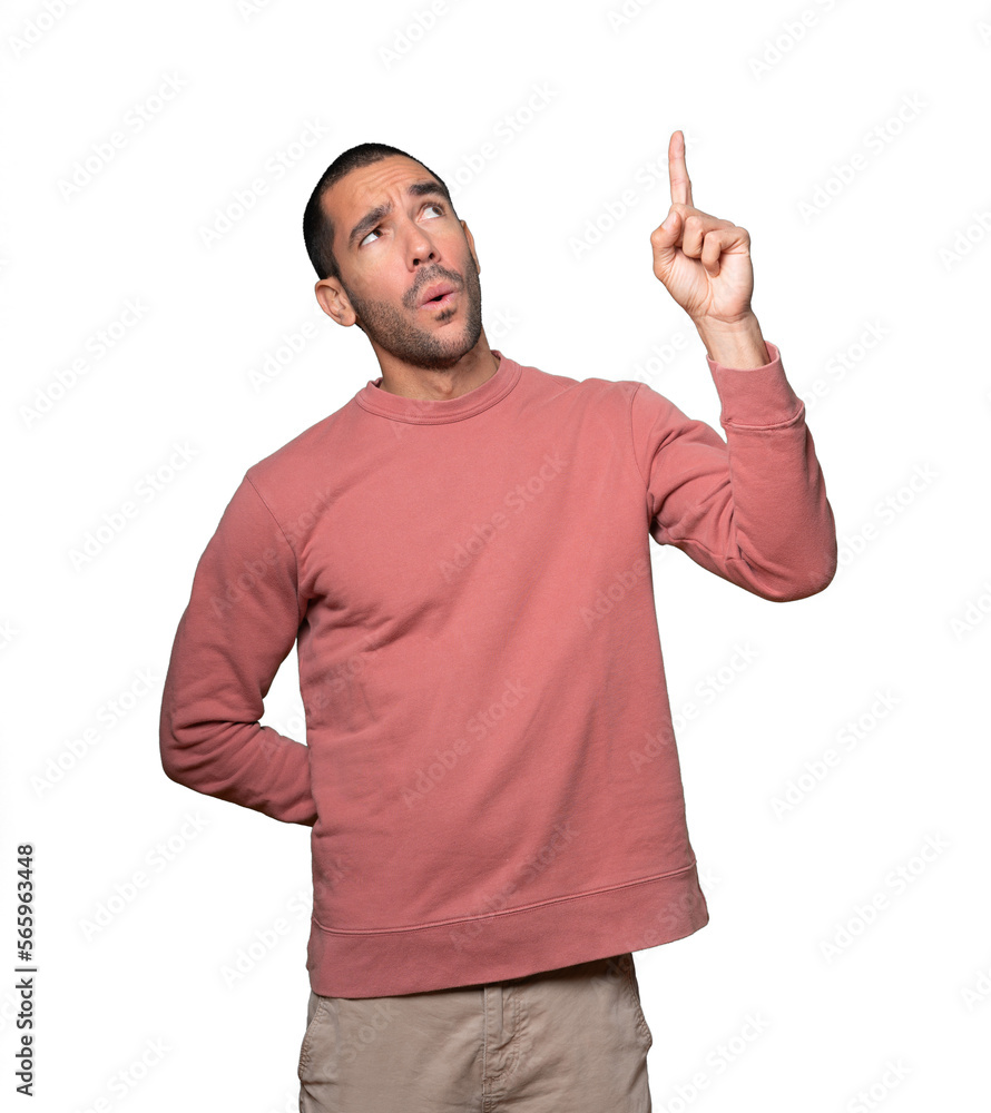Amazed young man pointing up with his finger Amazed young man pointing up with his finger