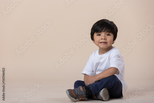 Mexican little boy sitting on the floor, looking at camera photo
