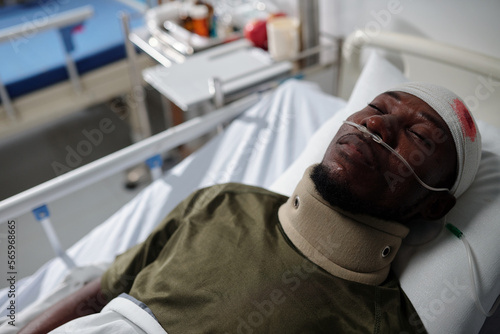 Soldier with splinter in head lying on bed in hospital ward