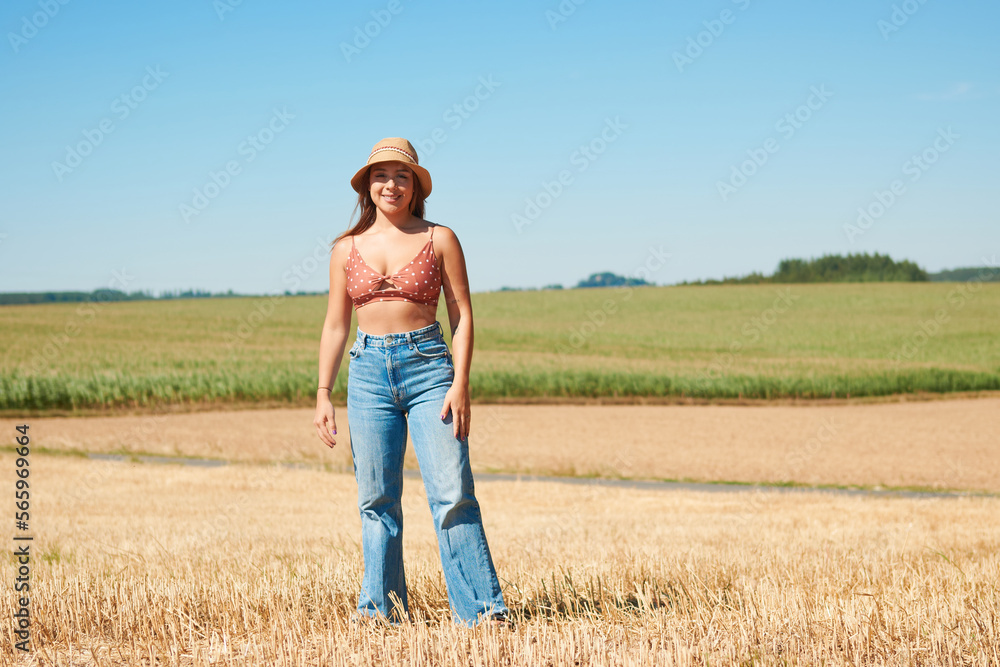 Hispanic woman enjoying the sunny day in the countryside while wearing a hat