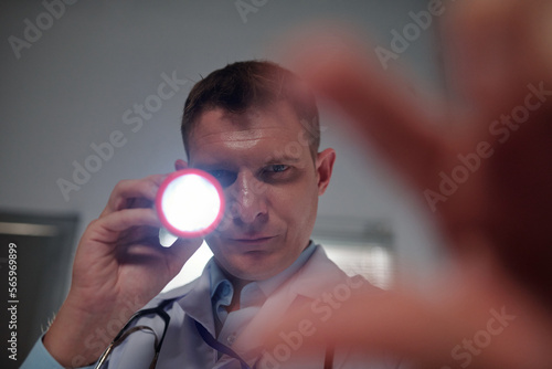 Medical worker using flashlight when checking is patient has concussion photo