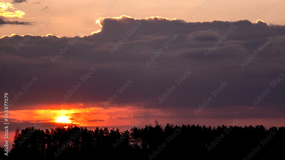 Sun breaks through the clouds. The rays of the sun break through the clouds. Silhouettes of trees against the backdrop of sunrise. Sun breaks through the clouds. The rays of the sun break through the clouds. Silhouettes of trees against the backdrop of sunrise.