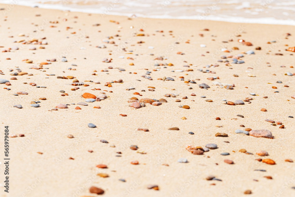Natural stones amber yellow colored on beige sand ans sea wave. Aesthetic minimal nature scene with pebble stones on sandy background. Summer vacation or relaxation concept, selective focus Natural stones amber yellow colored on beige sand ans sea wave. Aesthetic minimal nature scene with pebble stones on sandy background. Summer vacation or relaxation concept, selective focus