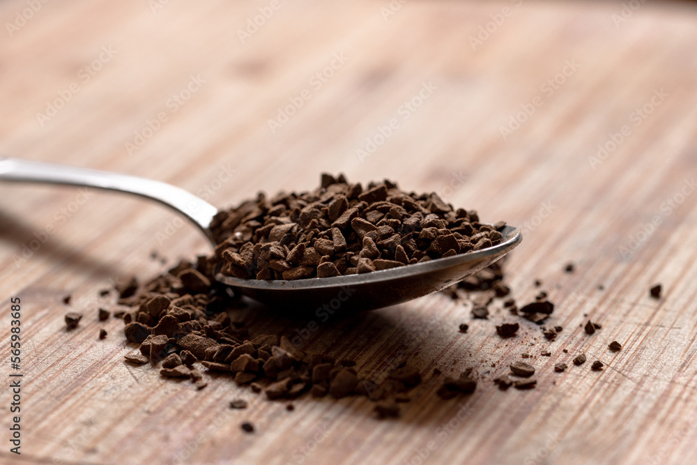 Instant coffee in an iron spoon on a wooden table Instant coffee in an iron spoon on a wooden table