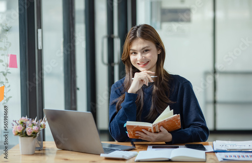 Happy smiling young asian business woman paper notebook and laptop in the office, Company worker woman.