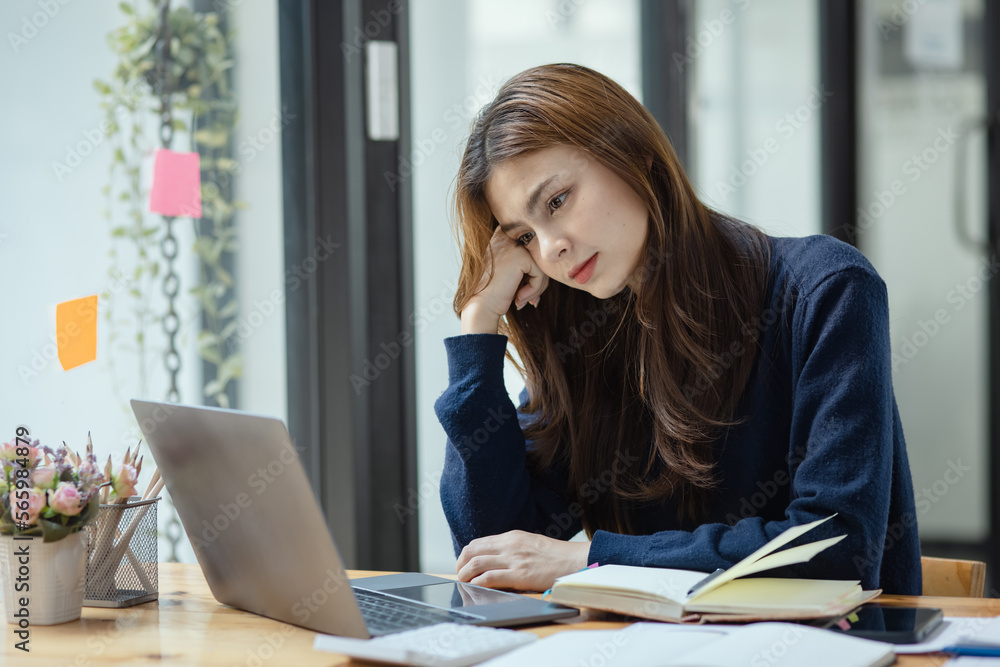 Young businesswoman are stressed and tired from work sitting at desk in the office, feeling sick at work, stress from work. Young businesswoman are stressed and tired from work sitting at desk in the office, feeling sick at work, stress from work.