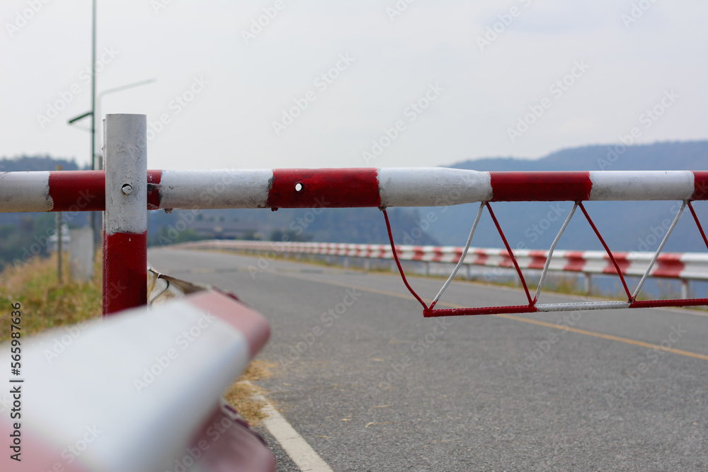 Guardrail traffic barrier painted red and white block the road line on crest reservoir dam.