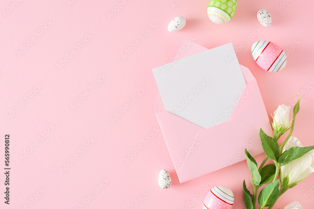 Easter celebration concept. Flat lay composition made of Easter eggs, envelope with letter and flowers on pastel pink background with empty space. Spring holiday card idea.