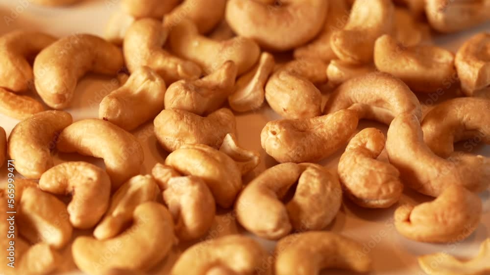 Cashew nuts from above. Close up 4k video with cashew on a white rotating plate. Cashew nuts from above. Close up 4k video with cashew on a white rotating plate.