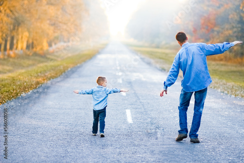 A Happy parent with child are walking along the road in the park on nature travel