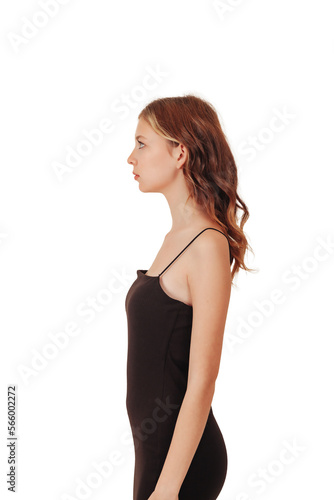 Test snapshot portrait of slender teen girl model posing in black elegant dress isolated white background, left side profile. Teenager girl shooting in studio. Fashion style concept. Copy text space