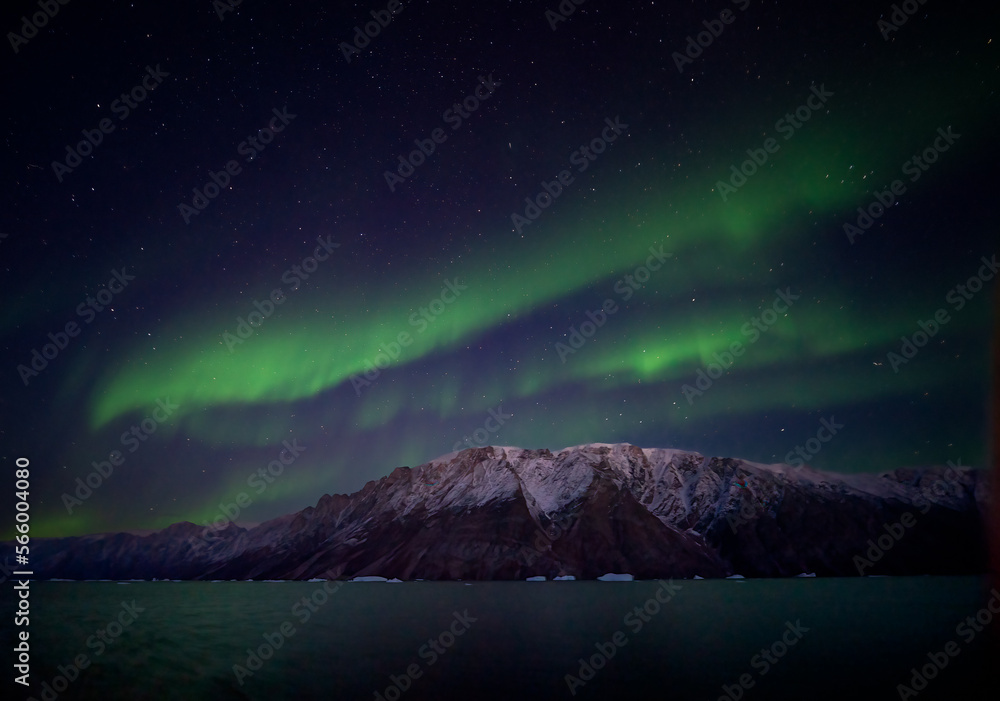 Aurora Borealis over mountains in East Greenland