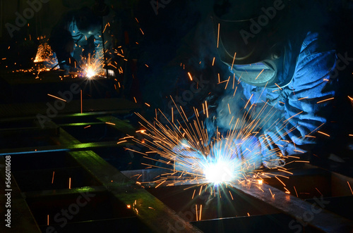 Workers wearing industrial uniforms and Welded Iron Mask at Steel welding plants, industrial safety first	
