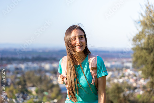 Smiling young woman with a backpack on the top of a the hill. Self-confidence.  © padnob