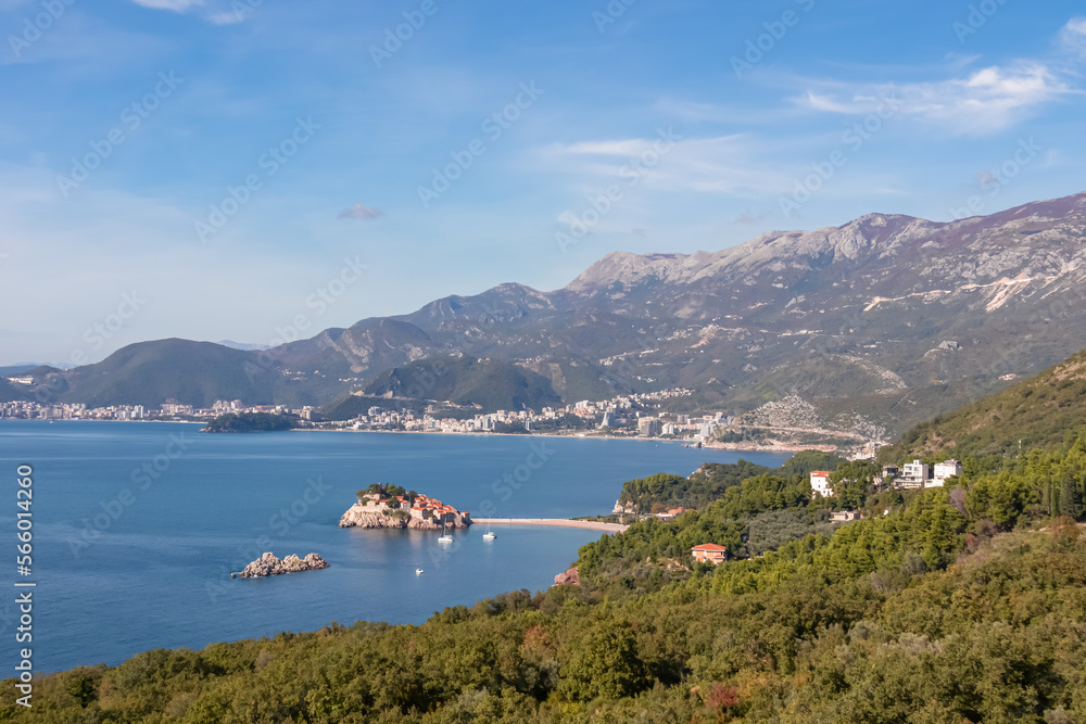 Obraz premium Aerial view of idyllic island Sveti Stefan (St. Stephen) in the Bay of Budva seen from Saint Sava, Adriatic Mediterranean Sea, Montenegro, Europe. Summer vacation at seaside with Dinaric Alps in back