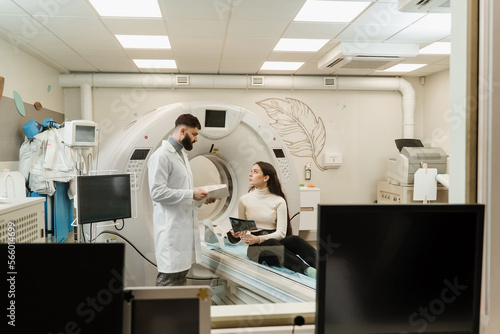 CT Doctor consulting patient and showing brains x-ray to patient in computed tomography room. CT scan radiologist showing x-ray of brains to girl patient in computed scanning room.