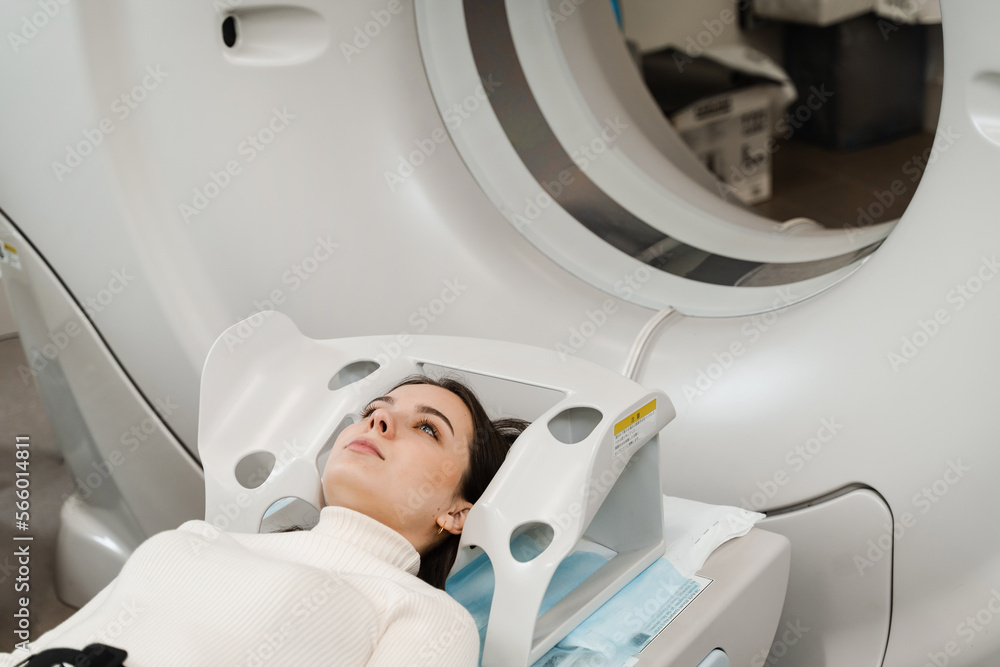 CT scan of brains of woman in medical clinic. Girl patient is doing computed tomography x-ray examination of tumor in his head in a CT scan room. CT scan of brains of woman in medical clinic. Girl patient is doing computed tomography x-ray examination of tumor in his head in a CT scan room.