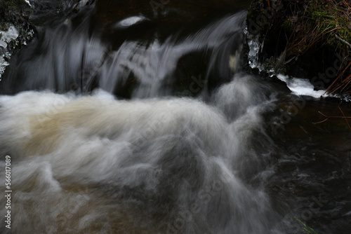 Rapidly flowing water in a stream in the nature in Finland in winter