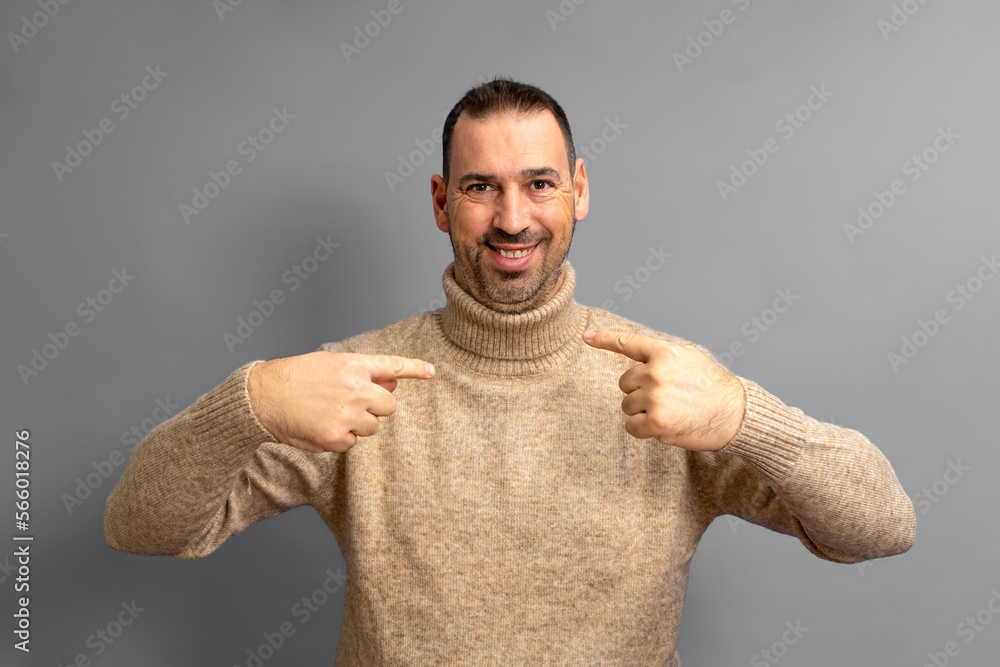 Handsome bearded hispanic man wearing turtleneck looking confident with smile on his face, pointing fingers to himself proud and happy Handsome bearded hispanic man wearing turtleneck looking confident with smile on his face, pointing fingers to himself proud and happy