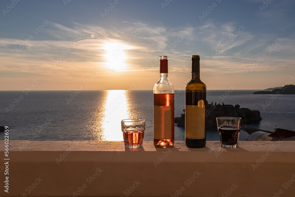 Drinking wine on balcony in luxury hotel in Budva Riviera with scenic view on idyllic Sveti Stefan island at sunset, Adriatic Mediterranean Sea, Montenegro, Europe. Summer seaside vacation in resort Drinking wine on balcony in luxury hotel in Budva Riviera with scenic view on idyllic Sveti Stefan island at sunset, Adriatic Mediterranean Sea, Montenegro, Europe. Summer seaside vacation in resort