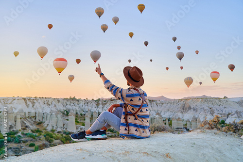 Man traveler vacations beautiful destination in Goreme, Turkey. Fabulous Kapadokya with flying air balloons at sunrise, Anatolia photo