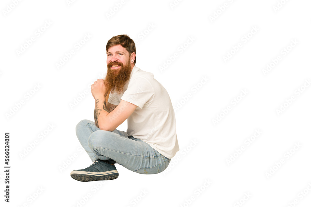 Adult redhead man sitting on the floor isolated Adult redhead man sitting on the floor isolated