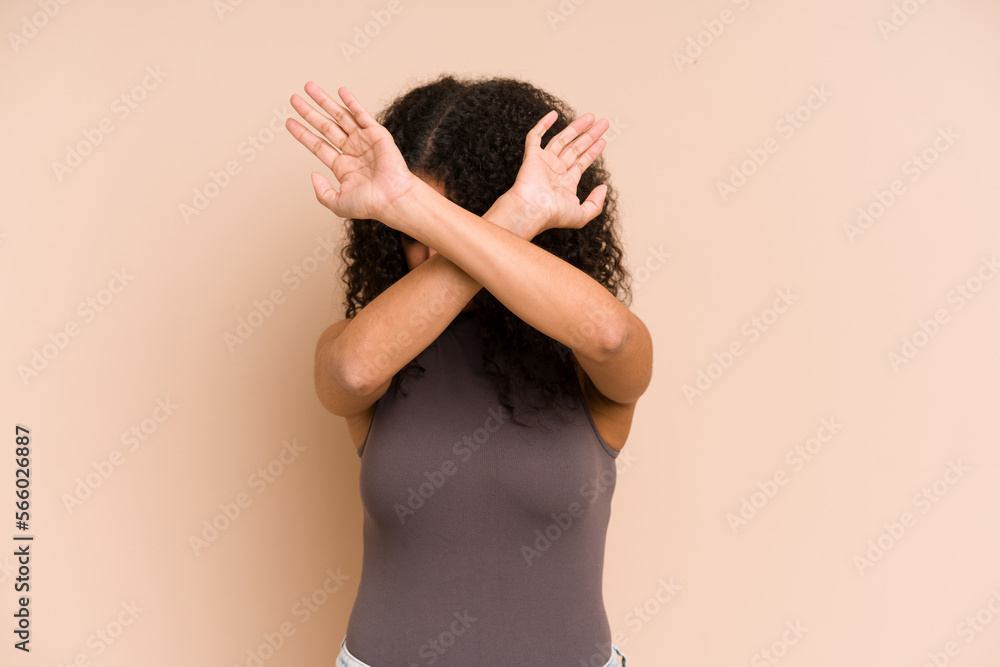 Young african american curly woman isolated keeping two arms crossed, denial concept. Young african american curly woman isolated keeping two arms crossed, denial concept.