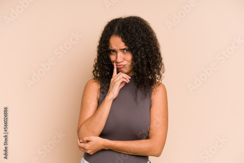 Young african american curly woman isolated contemplating, planning a strategy, thinking about the way of a business. © Asier