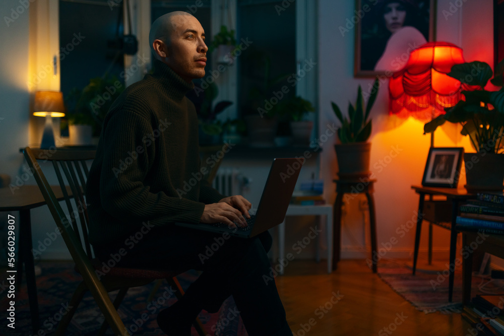 A caucasian with a laptop man sitting in a living room writing. A caucasian with a laptop man sitting in a living room writing.