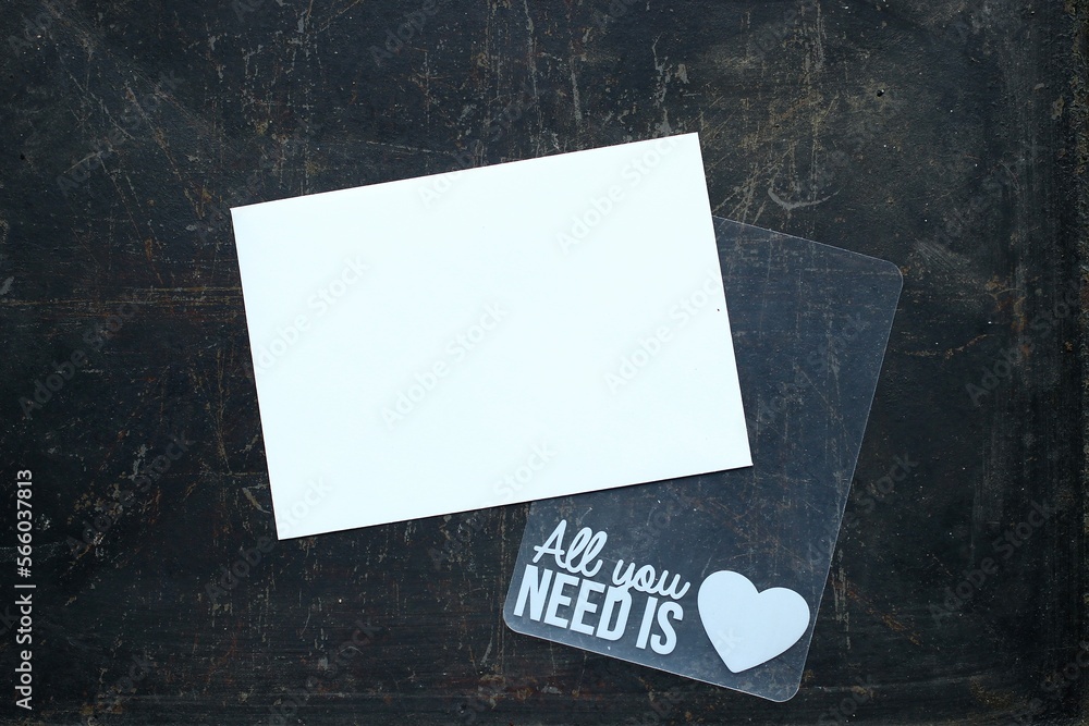 Biała kartka z miejscem na tekst i szablon "All you need is love" na ciemnym tle. Flat lay  - obrazy, fototapety, plakaty 