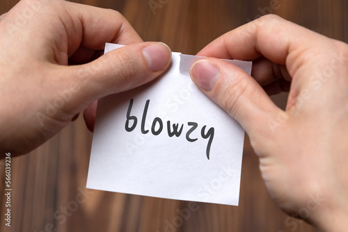 Photos Hands tearing off paper with inscription blowzy