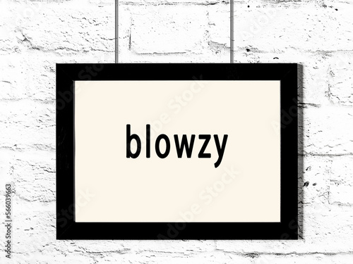 Принти на полотні Black frame hanging on white brick wall with inscription blowzy