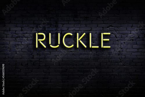 Night view of neon sign on brick wall with inscription ruckle photo