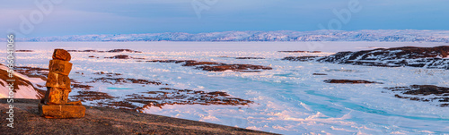 Inukshuk overlooking arctic landscape, Nunavut, Canada. photo