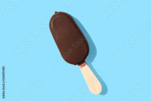Foto chocolate ice cream on a stick on blue pastel background