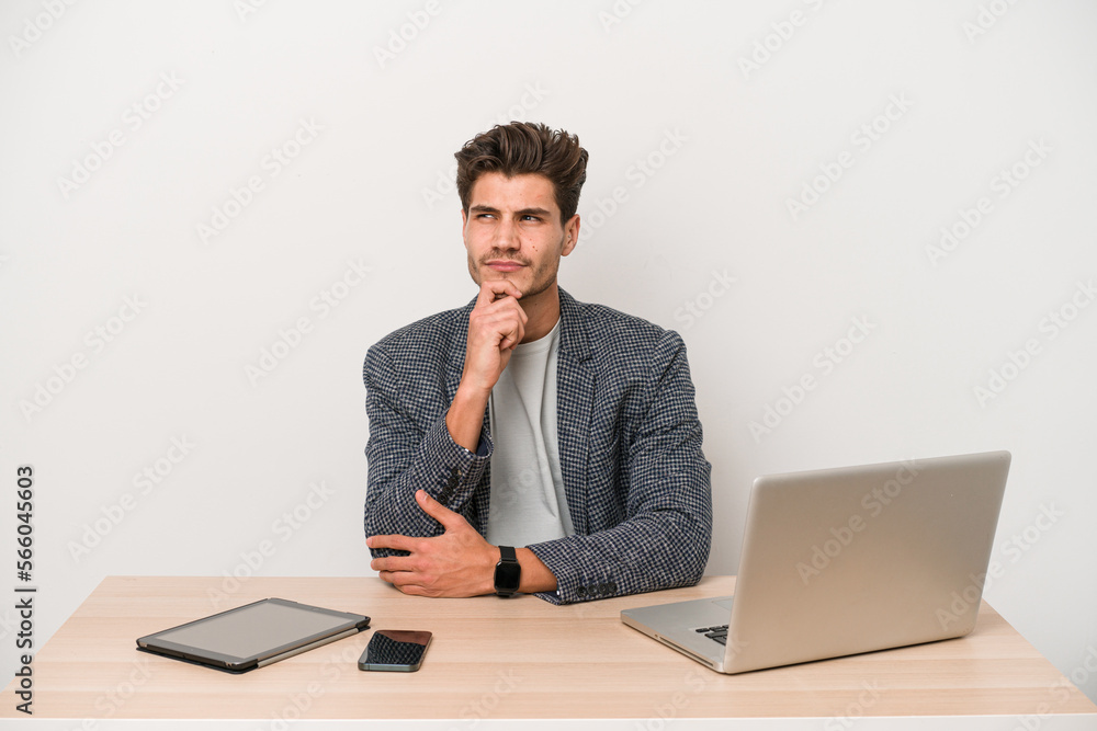 Young entrepreneur man working with a laptop isolated looking sideways with doubtful and skeptical expression. Young entrepreneur man working with a laptop isolated looking sideways with doubtful and skeptical expression.