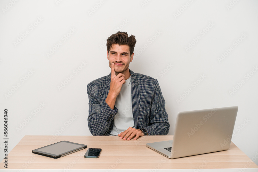 Young entrepreneur man working with a laptop isolated contemplating, planning a strategy, thinking about the way of a business. Young entrepreneur man working with a laptop isolated contemplating, planning a strategy, thinking about the way of a business.
