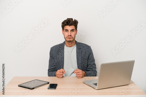 Young entrepreneur man working with a laptop isolated sad, serious face, feeling miserable and displeased.