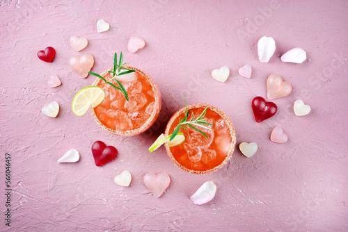 Klassischer Rosa Daiquiri mit Rum, Orangen Likör und Limetten Saft serviert als Valentinstag Geschenk in zwei Gläsern und dekoriert mit Herzen photo