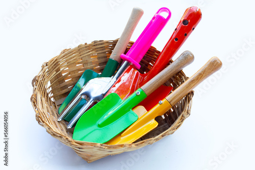 Garden shovel with fork in bamboo basket on white background. Garden tools