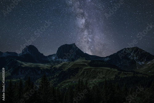 Starry Night in the Swiss Alps: Majestic Gantrisch Mountains with Milky Way and Summer Hills. Gurnigel Pass near Thun, Canton of Bern, Switzerland.