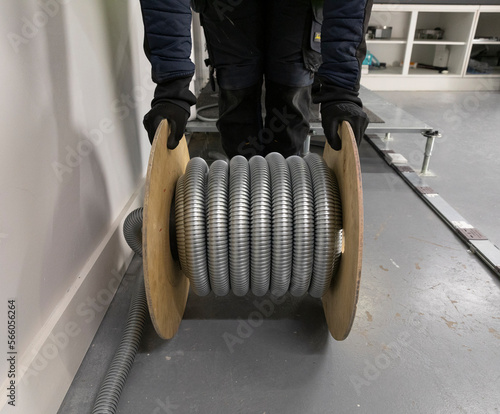 Steel Cable management baskets and trays with modular wiring, T conduit connector, drum of armoured cable, electrical installation