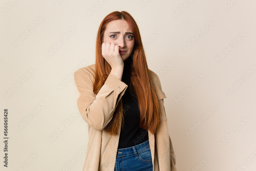 Young red hair woman isolated biting fingernails, nervous and very anxious. Young red hair woman isolated biting fingernails, nervous and very anxious.